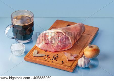 Raw Pork Knuckle, Dark Beer And Other Ingredients For Cooking Baked Pork Knuckle In Beer