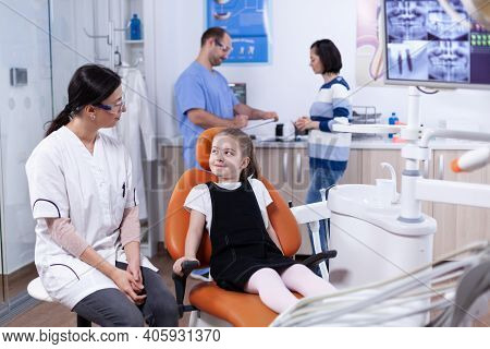 Little Girl Waiting For Professional Dental Hygine Examining Looking At Dentist Doctor. Child With H