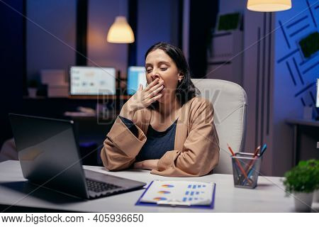 Entrepreneur Lady Yawns Working On Deadline In Dark Office Looking At Laptop Screen. Smart Woman Sit