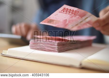 Close Up Of Woman Hand Counting Money Uang Indonesian Rupiah And Making Notes, Money Financial Manag