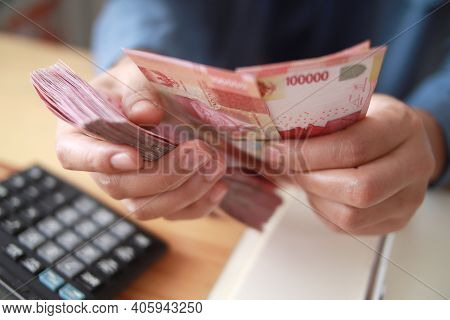 Close Up Of Woman Hand Counting Money Uang Indonesian Rupiah And Making Notes, Money Financial Manag