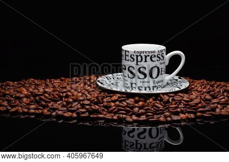 Coffee Mug On A Pile Of Coffee Beans On The Black Background.