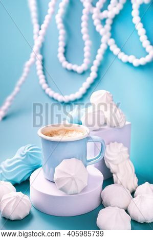 Meringues Of Different Colors On A Blue Background And Coffee. Espresso Cup With Foam. A Creative Sh