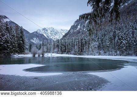 Frozen Winter Lake In The Mountains Covered With Snow. Plansar Lake, Jezersko Slovenia.