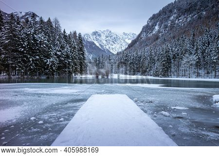 Frozen Winter Lake In The Mountains Covered With Snow. Plansar Lake, Jezersko Slovenia.