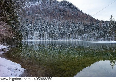 Frozen Winter Lake In The Mountains Covered With Snow. Plansar Lake, Jezersko Slovenia.