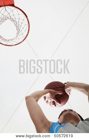 Man attempting to through basketball in to the basket