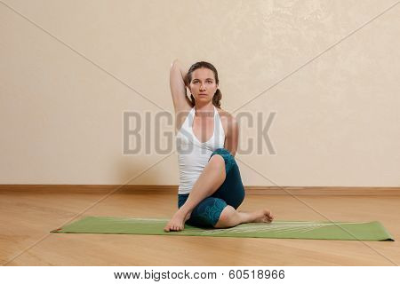Caucasian Woman Is Practicing Yoga At Studio (gomukhasana)