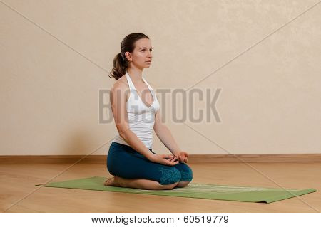 Caucasian Woman Is Practicing Yoga At Studio (vajrasana)