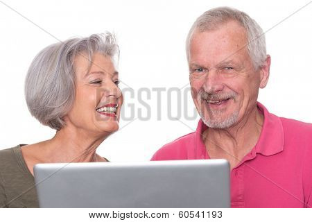 Senior couple with computer in front of white background