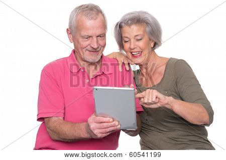 Senior couple with tablet computer in front of white background