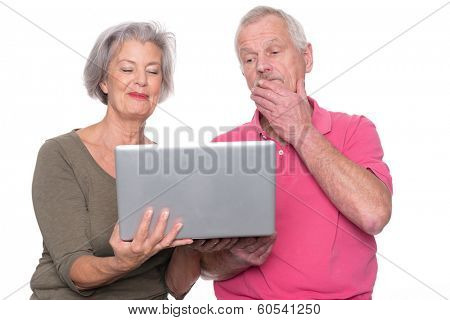 Senior couple with computer in front of white background