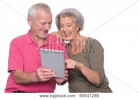 Senior couple with tablet computer in front of white background