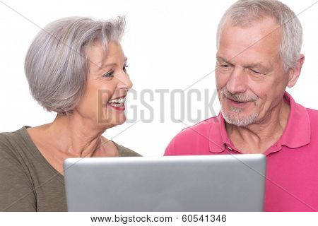 Senior couple with computer in front of white background