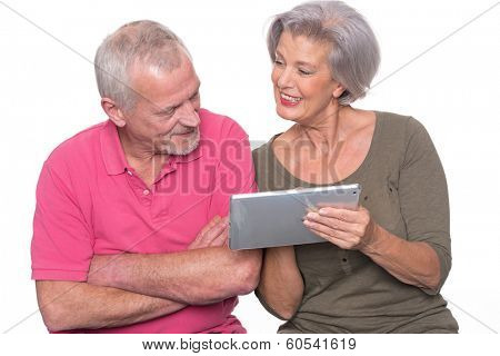 Senior couple with tablet computer in front of white background
