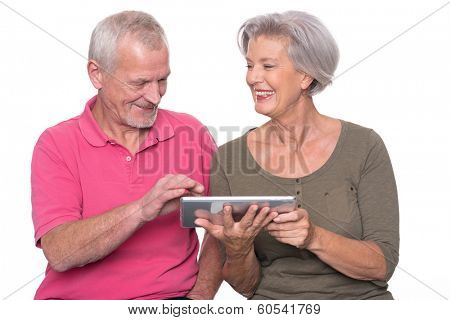 Senior couple with tablet computer in front of white background