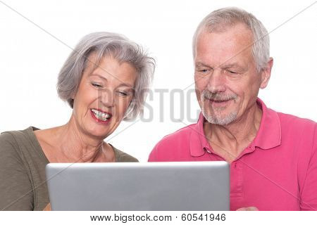 Senior couple with computer in front of white background