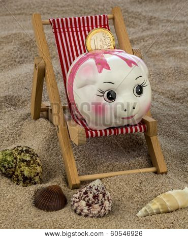 beach chair with euro currency on the sandy beach. symbolic photo for travel costs, holidays, vacations. save on holiday