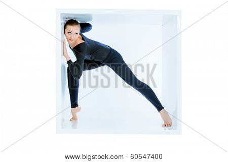 Modern bellet dancer posing with a cube at studio. Plastic body concept. Isolated over white.