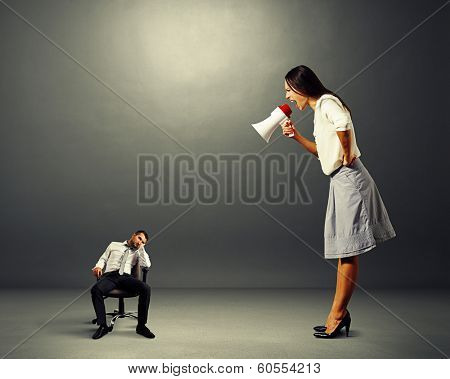 angry young woman screaming at small lazy man