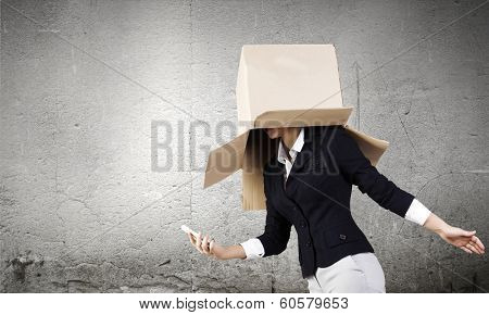 Businesswoman using mobile phone wearing carton box on head