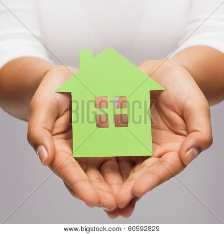 real estate and eco concept - closeup picture of woman hands holding green house