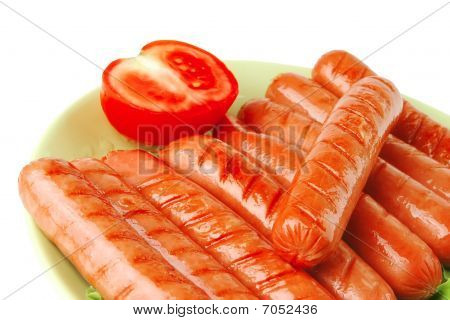 Salsichas grelhadas no prato verde