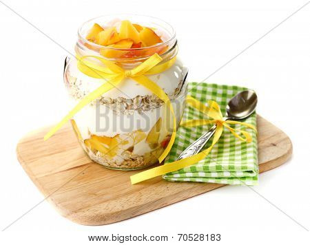 Healthy breakfast - yogurt with  fresh peach and muesli served in glass jar on wooden tray, isolated on white