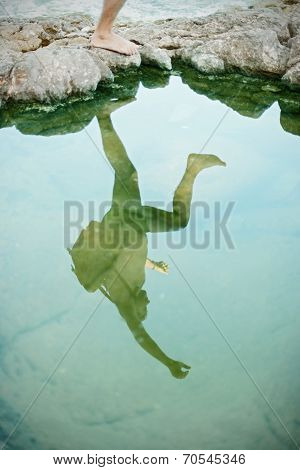 Reflection of a jumper over the cliff on the beach