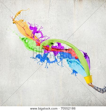 Close up of hand splashing colorful paint from bucket