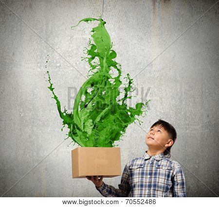 Young boy splashing colorful paint from carton box
