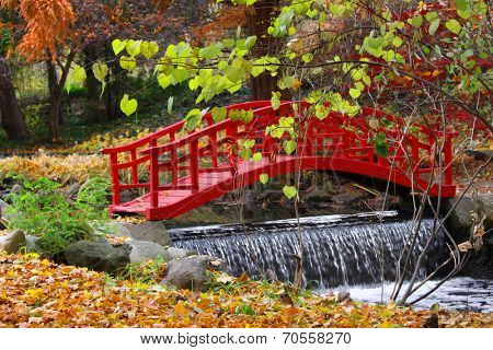 Red bridge and water falls in Japanese garden