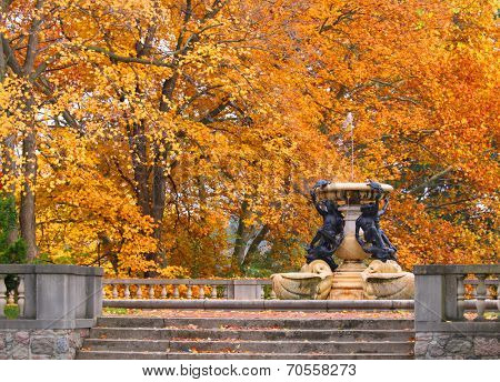 Fountain in historic Cranbrook house with autumn tree background