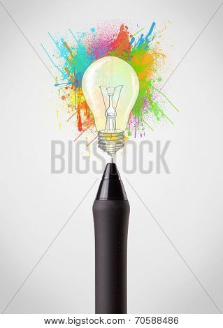 Pen close-up with colored paint splashes and lightbulb concept