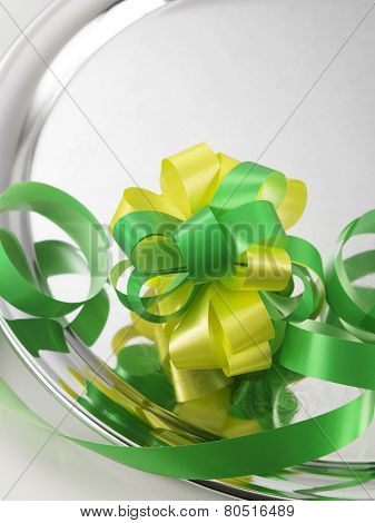 green yellow ribbon bows on the silver plate