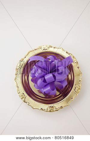 opening ceremony concept- purple ribbon bow on the golden plate