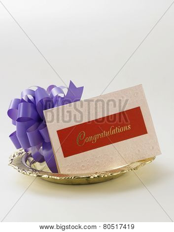 purple ribbon bow and a congraturation card