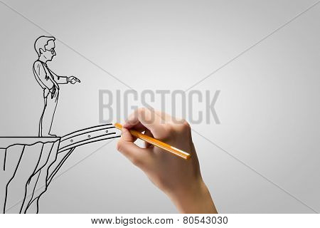 Human hand drawing caricature of man and bridge above gap