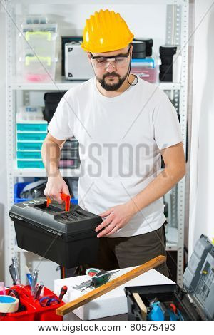 Manual worker holding a toolbox in workshop