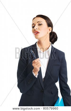 Photo of businesswoman holding pen, looking at the camera.