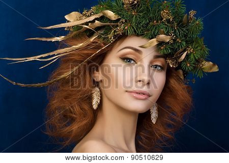 Portrait of young beautiful redhaired woman with firry wreath