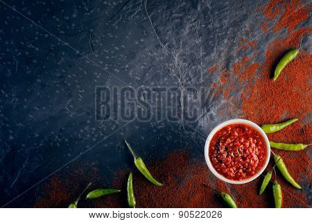 Chilli and garlic relish on black slate background from above