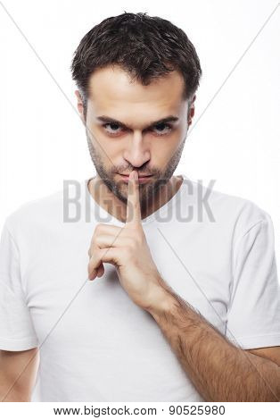 life style  and people concept: young man wearing white t-shirt making silence gesture, shhhhh!!