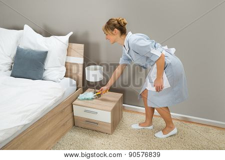 Maid Cleaning Dust With Feather Duster
