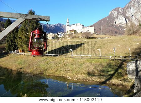Vintage Old Red Lantern Near The Small Village Amid The Mountains