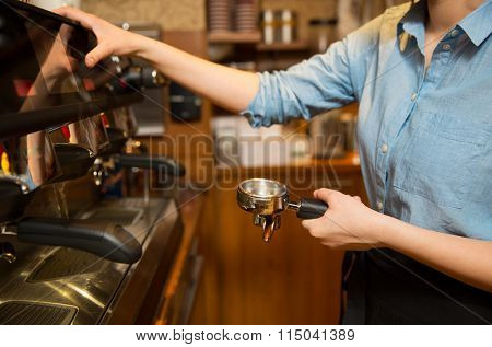 close up of woman making coffee by machine at cafe