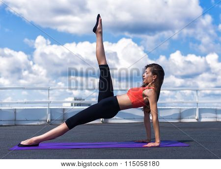 Beautiful Woman Doing A Yoga Exercise On He Rooftop Of A Skyscraper