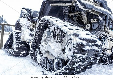 Closeup of a caterpillar snowmobile with snow