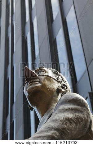 MONTREAL, CANADA-AUGUST 20th, 2014: Part of the statue The English Pug and the French Poodle.  Elegantly dressed and hidden behind masks, a man carries his English pug in Montreal, Canada.