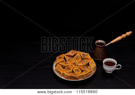 Cezve, Coffee Mug And A Plate Of Traditional Turkish Sweet Baklava. Copy Space, Black Background